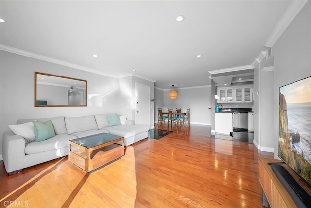 living area with baseboards, light wood-style flooring, ornamental molding, and recessed lighting