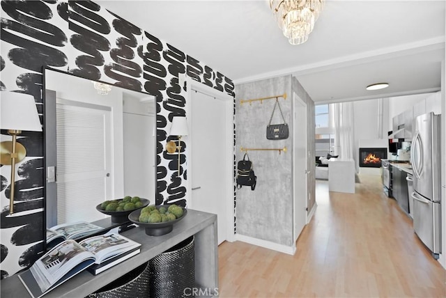 4215 Glencoe Ave Unit 407, Marina Del Rey, CA 90292 - kitchen featuring a warm lit fireplace, light wood-style flooring, a chandelier, and freestanding refrigerator