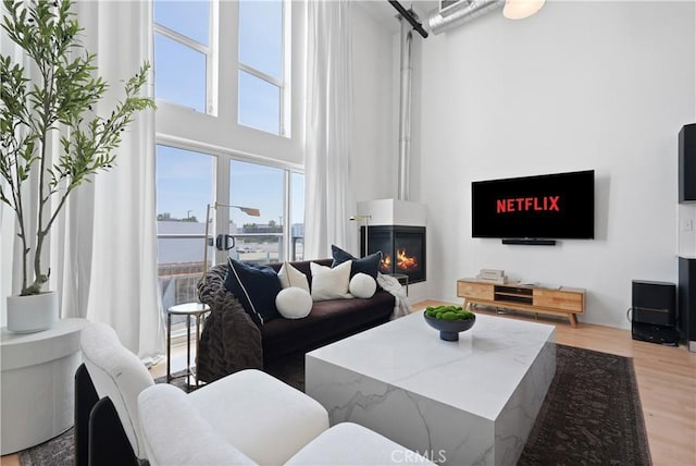 4215 Glencoe Ave Unit 407, Marina Del Rey, CA 90292 - living area featuring light wood-style floors, a towering ceiling, and a large fireplace