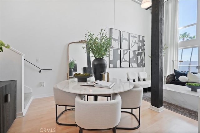 4215 Glencoe Ave Unit 407, Marina Del Rey, CA 90292 - dining room featuring baseboards, a towering ceiling, and light wood finished floors
