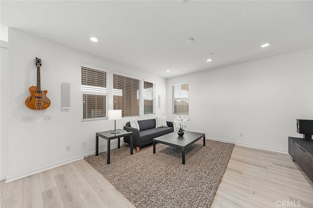 living area featuring recessed lighting, light wood finished floors, and baseboards