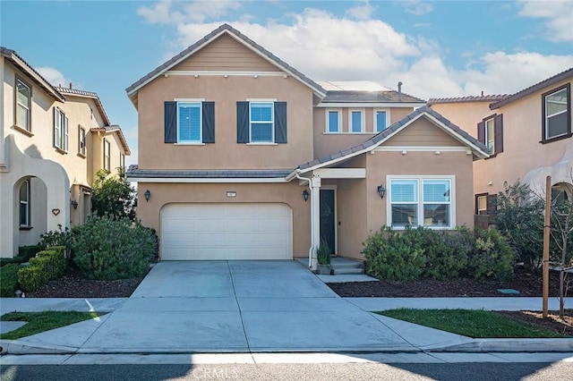 traditional-style house with an attached garage, a tile roof, concrete driveway, and stucco siding
