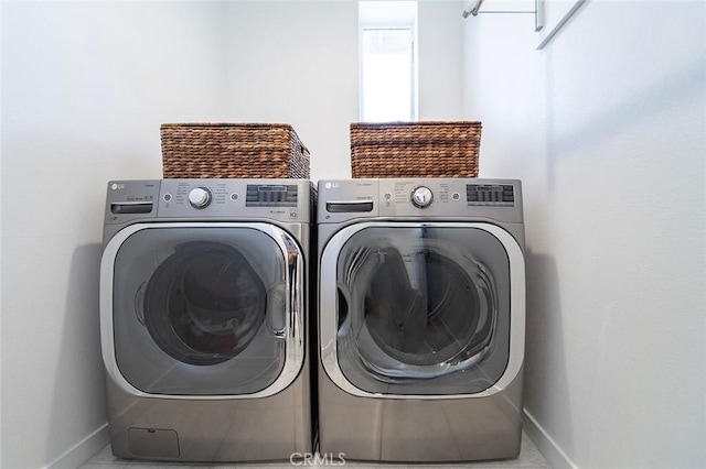 laundry room with separate washer and dryer, baseboards, and laundry area