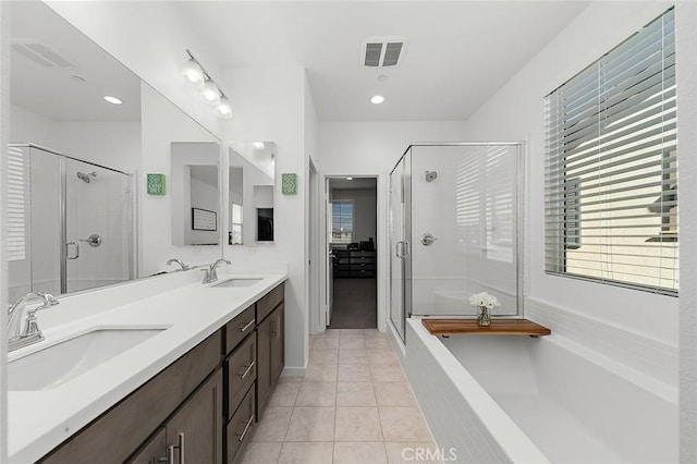 bathroom featuring tile patterned flooring, a sink, visible vents, and a stall shower
