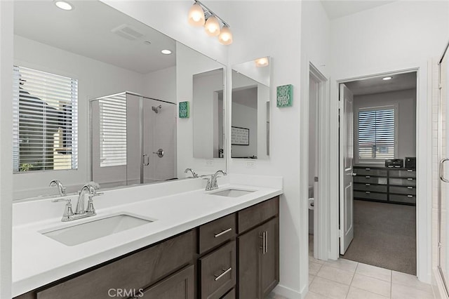bathroom with tile patterned flooring, a sink, and a shower stall