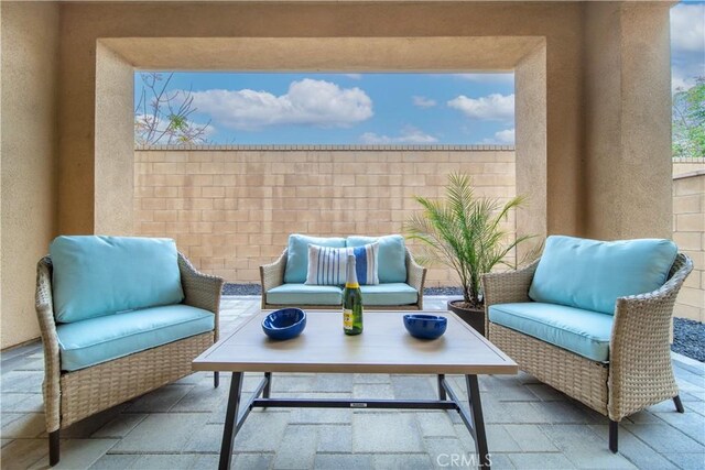 view of patio with an outdoor living space and fence