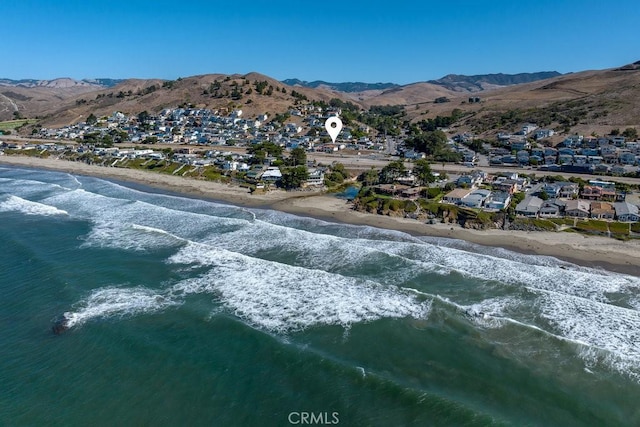 drone / aerial view featuring a beach view, a residential view, and a water and mountain view