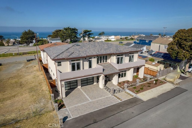 view of front of property featuring fence, driveway, stucco siding, and a garage