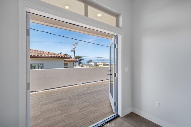 doorway to outside featuring baseboards, wood finished floors, and a healthy amount of sunlight
