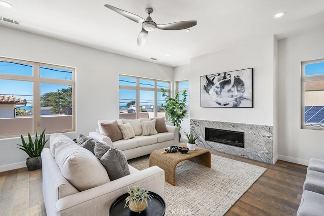 living area featuring a wealth of natural light, baseboards, a fireplace, and visible vents