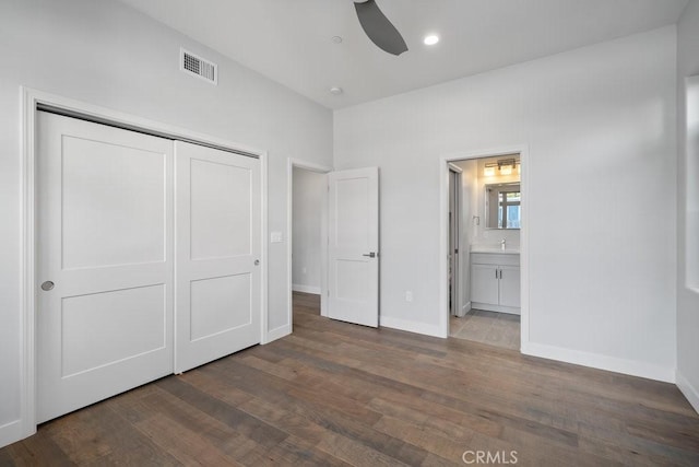unfurnished bedroom with a closet, visible vents, baseboards, wood finished floors, and recessed lighting