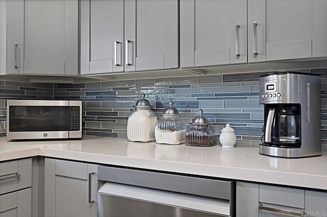 3685 Vista Campana N Unit 72, Oceanside, CA 92057 - kitchen view of stainless steel microwave, light countertops, and backsplash