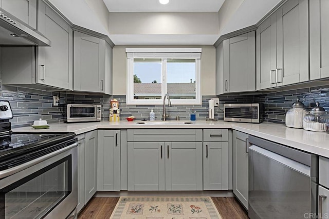 3685 Vista Campana N Unit 72, Oceanside, CA 92057 - kitchen featuring stainless steel appliances, a sink, gray cabinets, exhaust hood, and recessed lighting