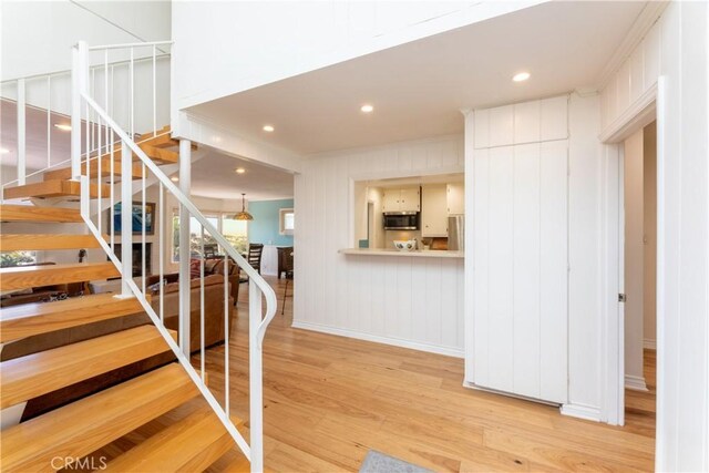16865 S Pacific Ave, Sunset Beach, CA 90742 - staircase featuring wood finished floors, baseboards, crown molding, and recessed lighting
