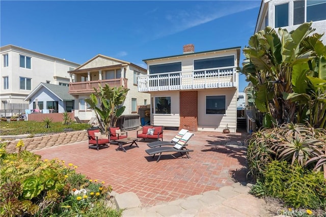 16865 S Pacific Ave, Sunset Beach, CA 90742 - rear view of property featuring a balcony, a patio area, a chimney, brick siding, and an outdoor hangout area