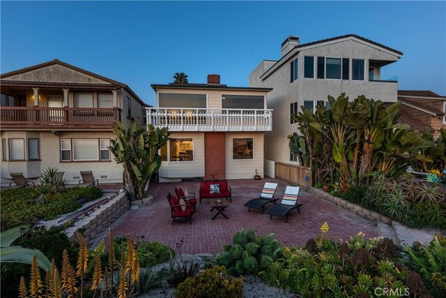16865 S Pacific Ave, Sunset Beach, CA 90742 - rear view of property featuring a patio, a balcony, and a chimney