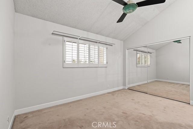 627 Avery Pl, Long Beach, CA 90807 - unfurnished bedroom with carpet floors, lofted ceiling, a closet, baseboards, and a textured ceiling