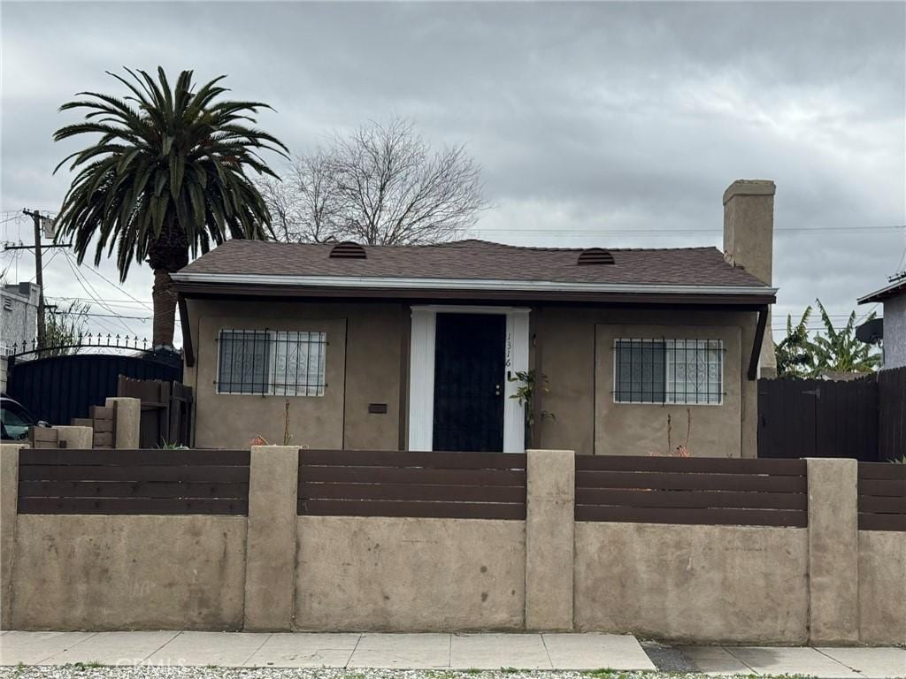 1316 W 73rd, Los Angeles, CA 90044 - bungalow-style house with stucco siding and a fenced front yard