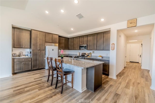 14168 Georgetown St, Hesperia, CA 92344 - kitchen with stainless steel microwave, freestanding refrigerator, stove, light wood-style floors, and recessed lighting