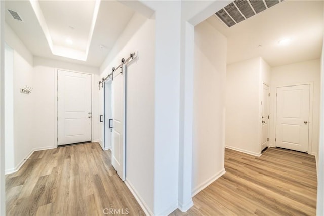 14168 Georgetown St, Hesperia, CA 92344 - hallway with light wood-type flooring, a barn door, baseboards, and a raised ceiling