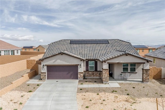 14168 Georgetown St, Hesperia, CA 92344 - view of front of property featuring a garage, stone siding, roof mounted solar panels, and stucco siding