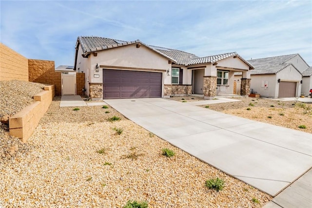 14168 Georgetown St, Hesperia, CA 92344 - view of front of property with stone siding, stucco siding, concrete driveway, an attached garage, and a gate