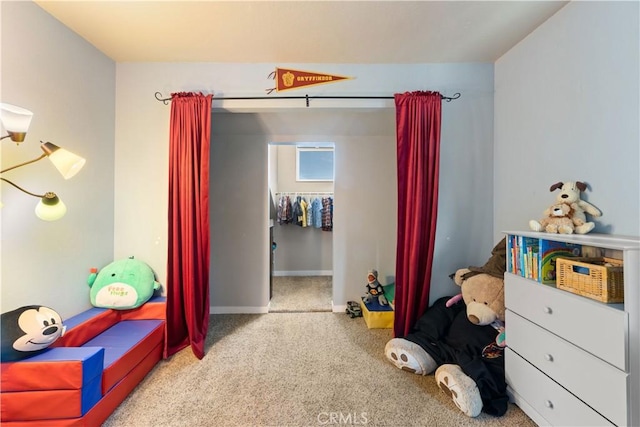 carpeted bedroom featuring baseboards and a spacious closet