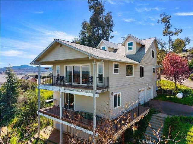 back of house featuring a garage and a mountain view