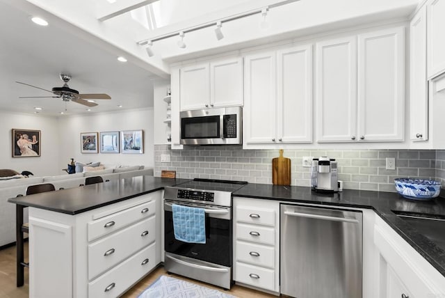 1552 Camino Del Mar Unit 623/625, Del Mar, CA 92014 - kitchen with stainless steel appliances, dark countertops, open floor plan, a peninsula, and white cabinets