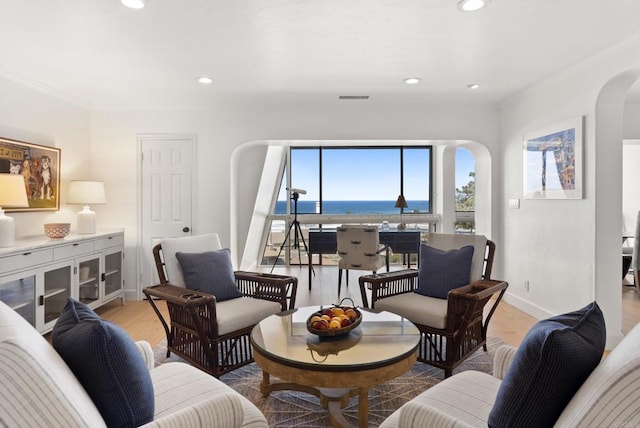 1552 Camino Del Mar Unit 623/625, Del Mar, CA 92014 - living area featuring arched walkways, light wood-style flooring, crown molding, baseboards, and a water view