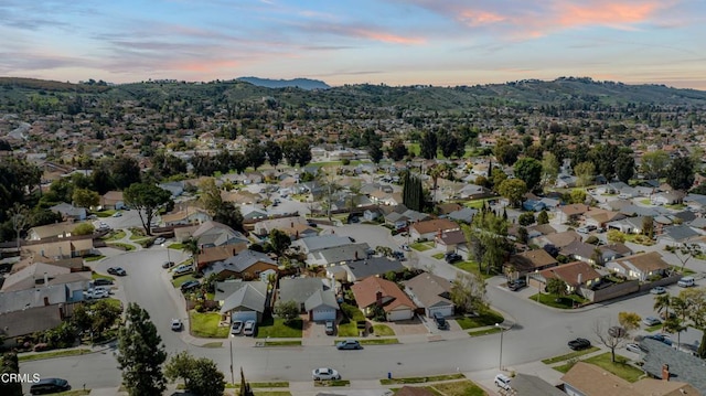 aerial view at dusk featuring a residential view and a mountain view