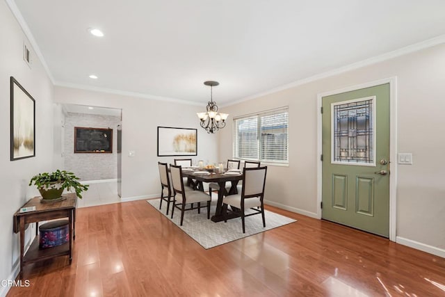 dining area featuring crown molding, baseboards, and wood finished floors