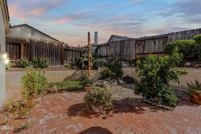 patio terrace at dusk with a fenced backyard