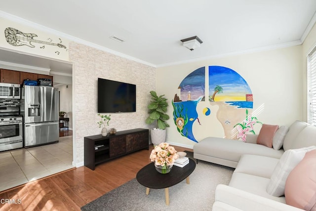 living area with light wood-style flooring, ornamental molding, and visible vents