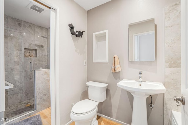 full bath with a stall shower, baseboards, visible vents, and toilet