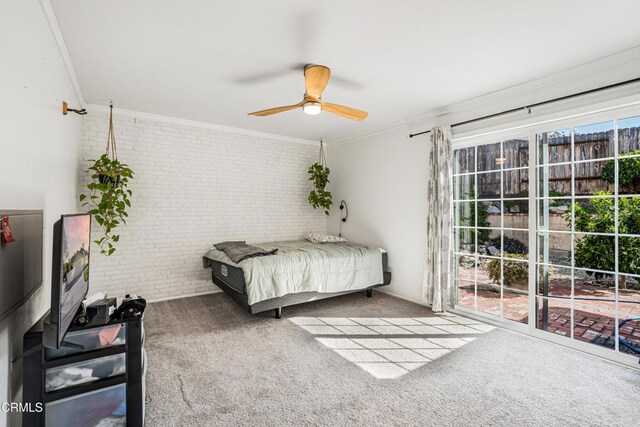 carpeted bedroom featuring multiple windows, ornamental molding, brick wall, and ceiling fan