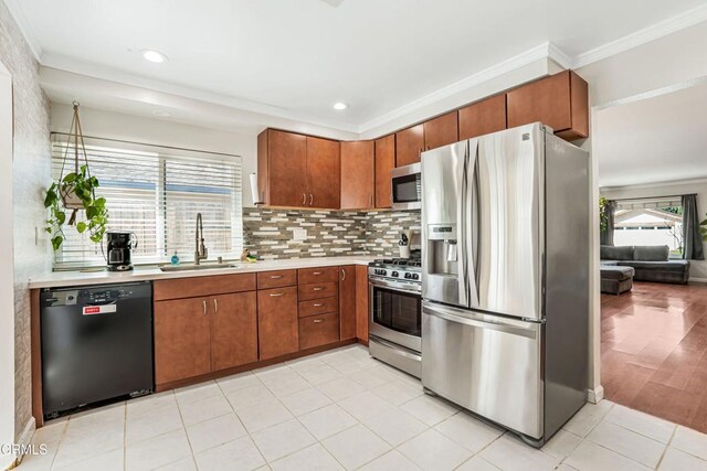 kitchen with ornamental molding, light countertops, a sink, and stainless steel appliances