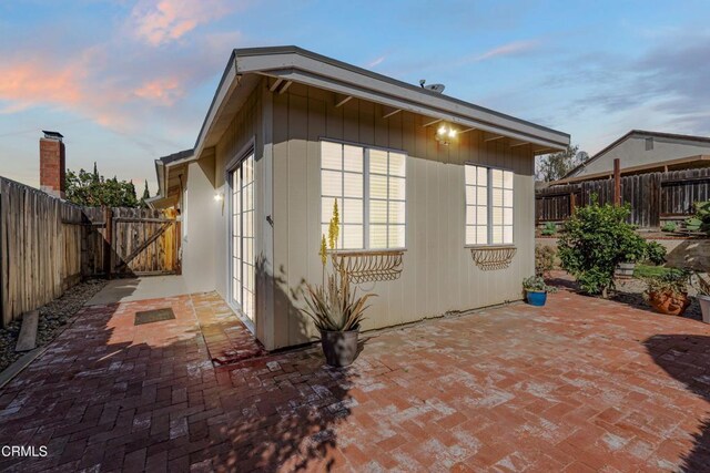 view of side of property with a patio and a fenced backyard
