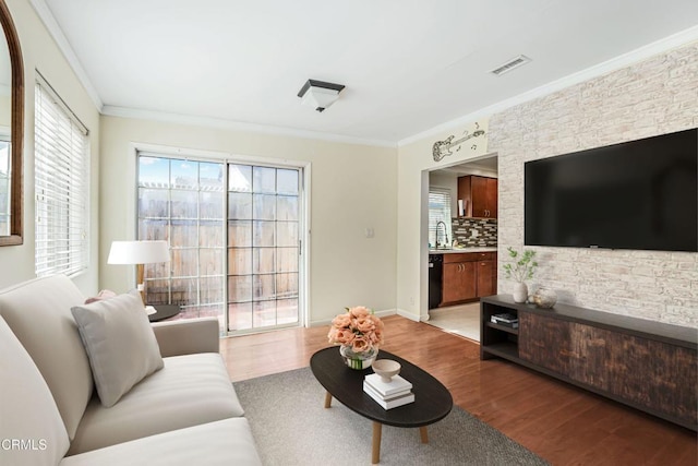 living room featuring ornamental molding, visible vents, and light wood-style floors