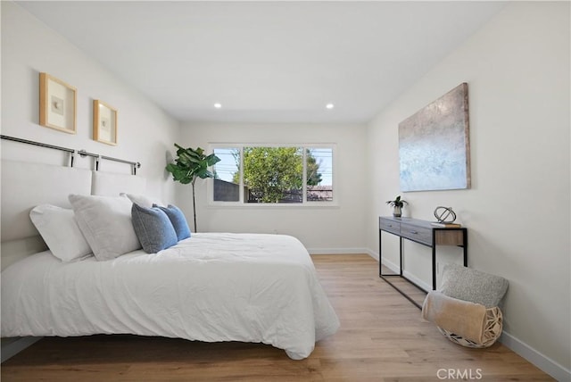 bedroom with baseboards, light wood finished floors, and recessed lighting