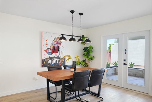 dining room with light wood-style flooring, baseboards, and french doors