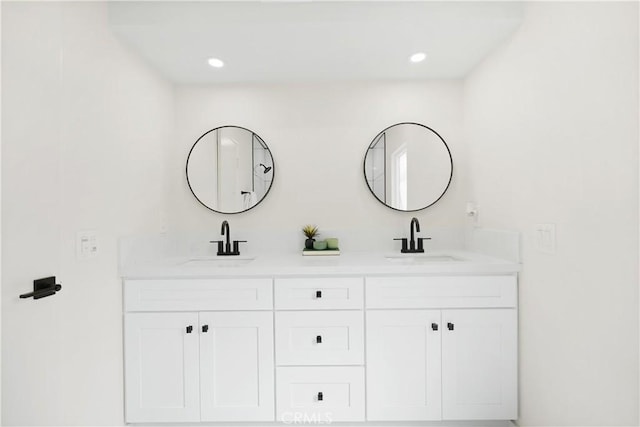 bathroom with a sink, recessed lighting, and double vanity