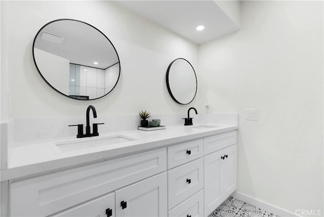 full bath with baseboards, a sink, and double vanity