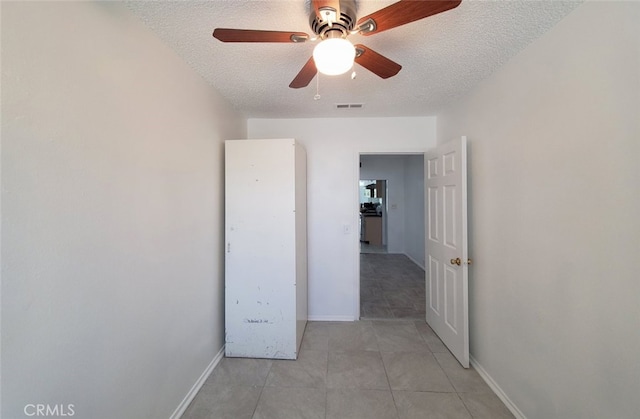 1020 E Rowland Ave, West Covina, CA 91790 - empty room featuring a textured ceiling, ceiling fan, and light tile patterned floors
