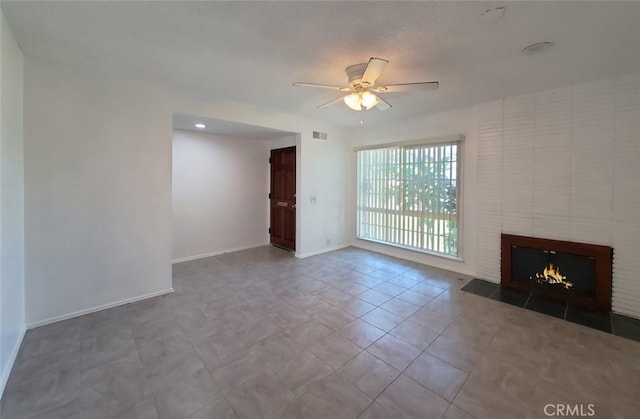unfurnished living room featuring visible vents, a ceiling fan, baseboards, and a fireplace
