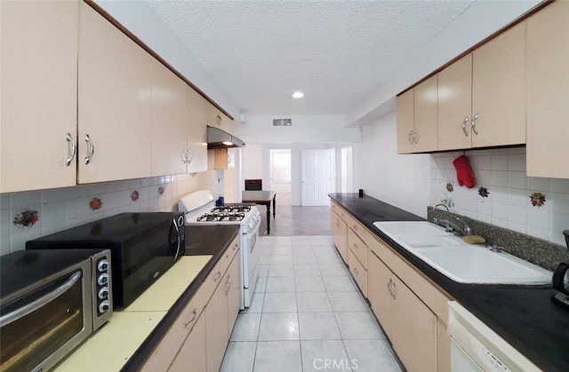 1020 E Rowland Ave, West Covina, CA 91790 - kitchen with white appliances, a textured ceiling, backsplash, under cabinet range hood, and light tile patterned floors