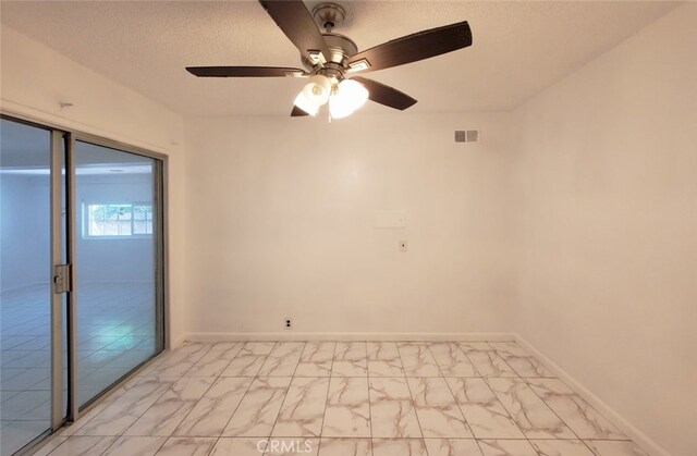 spare room with marble finish floor, baseboards, a ceiling fan, and visible vents