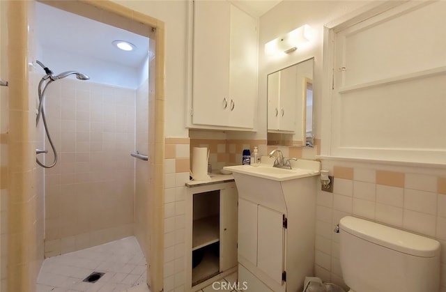bathroom featuring tile walls, vanity, a shower stall, and toilet