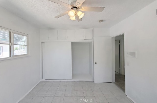 1020 E Rowland Ave, West Covina, CA 91790 - unfurnished bedroom with a textured ceiling, a closet, light tile patterned floors, and ceiling fan