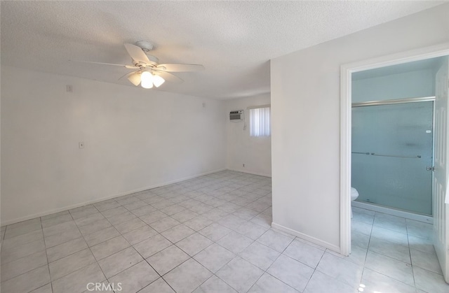 spare room featuring light tile patterned floors, baseboards, a textured ceiling, and ceiling fan